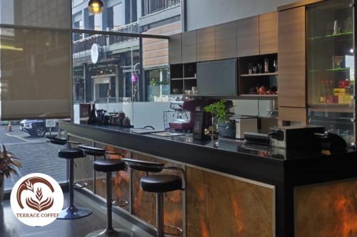 a bar with stools in front of a building at Aston Imperial Bekasi Hotel & Conference Center in Bekasi