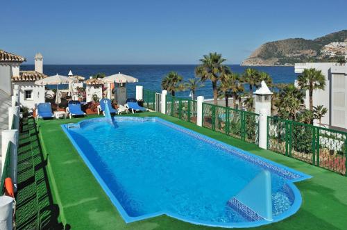 a swimming pool with the ocean in the background at Sol Los Fenicios in La Herradura