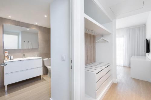 a white bathroom with a sink and a toilet at Sol Fuerteventura Jandia - All Suites in Morro del Jable