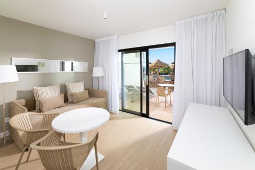 a living room with a couch and a table at Sol Fuerteventura Jandia - All Suites in Morro del Jable