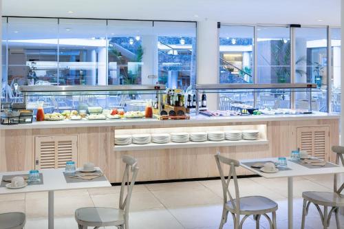 a restaurant with two tables and chairs and a counter at Sol Fuerteventura Jandia - All Suites in Morro del Jable