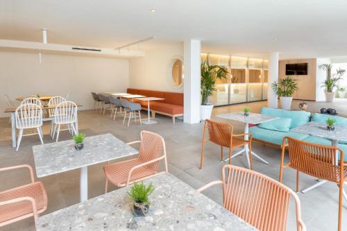 a restaurant with tables and chairs and a couch at Sol Fuerteventura Jandia - All Suites in Morro del Jable