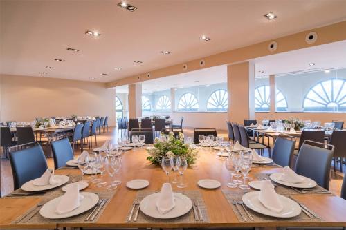 a large dining room with a long table and chairs at Barceló Costa Ballena Golf & Spa in Costa Ballena