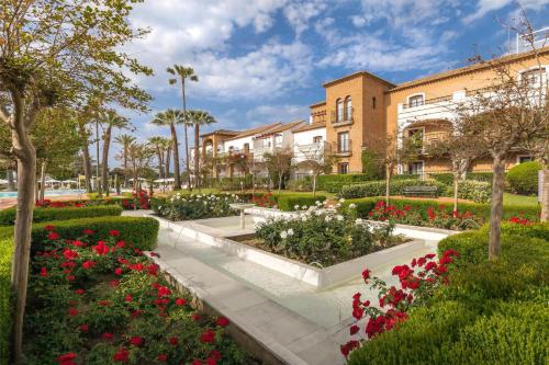 a garden in front of a building with flowers at Barceló Isla Canela in Isla Canela
