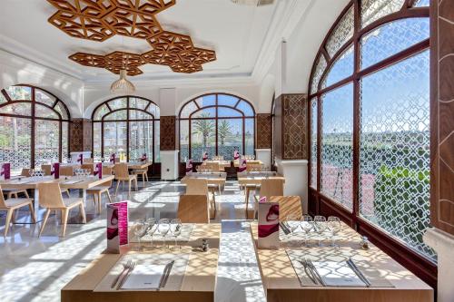 a restaurant with tables and chairs and large windows at Barceló Isla Canela in Isla Canela