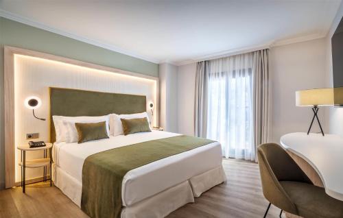 a hotel room with a large bed and a chair at Barceló Isla Canela in Isla Canela