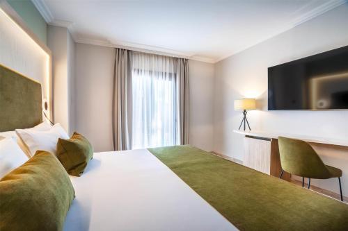 a hotel room with a large bed and a television at Barceló Isla Canela in Isla Canela