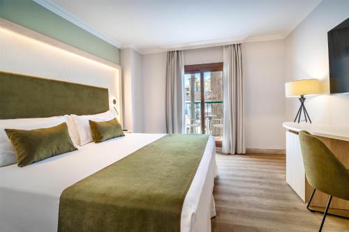 a hotel room with a large bed and a desk at Barceló Isla Canela in Isla Canela