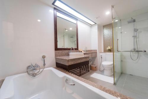 a bathroom with a tub and a sink and a shower at Khum Phucome Hotel -SHA Extra Plus in Chiang Mai