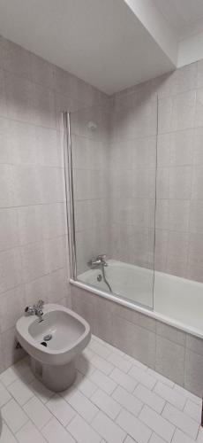 a bathroom with a shower and a toilet and a tub at Placido's in Aveiro