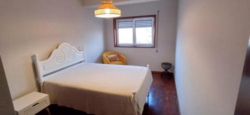 a bedroom with a white bed and a window at Placido's in Aveiro