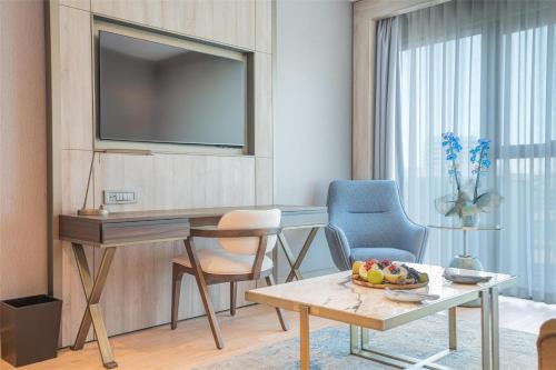 a living room with a television and a table and chairs at Radisson Hotel Istanbul Merter in Istanbul