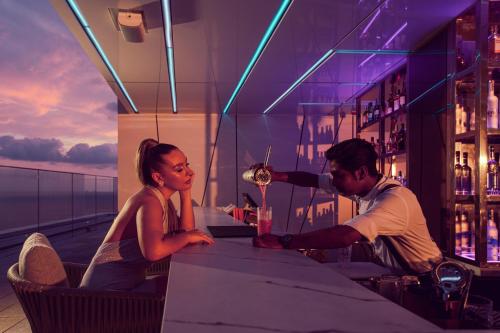 a man and a woman sitting at a bar with a drink at Cinnamon Life at City of Dreams in Colombo