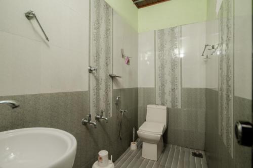 a bathroom with a toilet and a sink and a shower at Munroe Island Lake Resort in Kollam