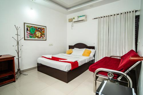 a bedroom with a bed and a chair in it at Munroe Island Lake Resort in Kollam