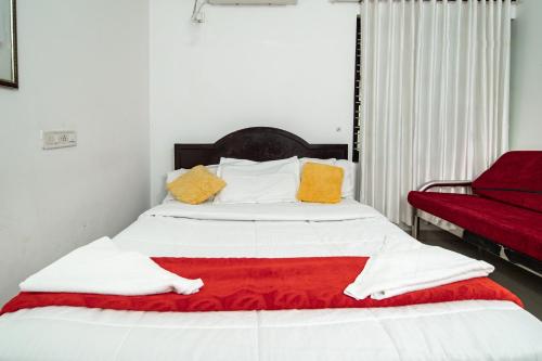 a bed with a red and yellow blanket on it at Munroe Island Lake Resort in Kollam