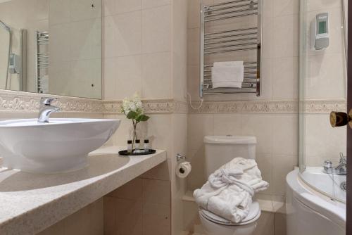 a white bathroom with a sink and a toilet at Passage House Hotel in Newton Abbot