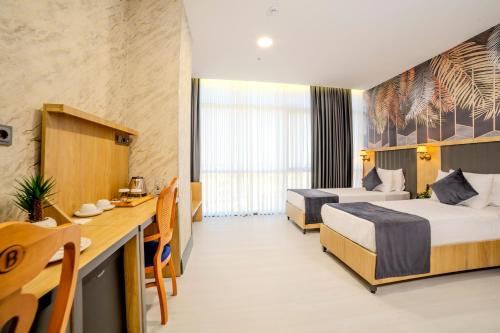 a hotel room with two beds and a desk at Bulton Hotel Airport in Arnavutköy