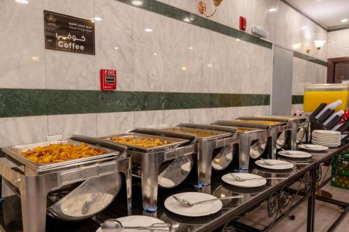 a buffet line with plates and trays of food at Maysan AL Taqwa in Al Madinah