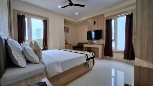 a bedroom with a bed and a flat screen tv at Park Eastern Hotel in Kolkata