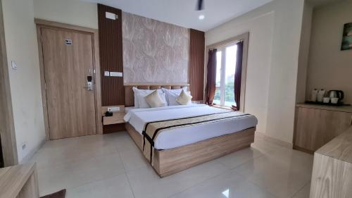 a bedroom with a large bed with a window at Park Eastern Hotel in Kolkata