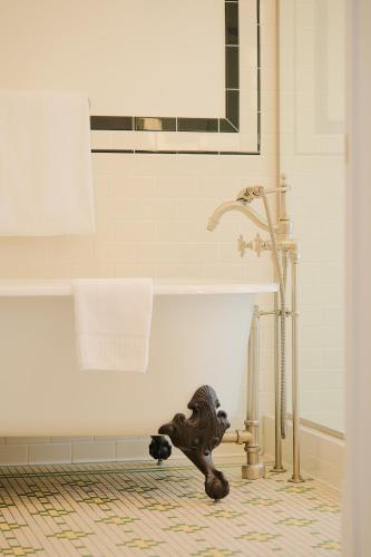 a bathroom with a tub with a lion statue next to it at The Oxford Hotel in Denver