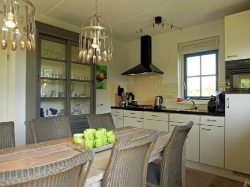a kitchen with a wooden table with chairs and a dining room at Holiday Home in Schoorl near Sandy Beaches in Schoorl