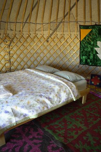 a large bed in a yurt with a mattress at Yurt camp Sonun in Bokonbayevo