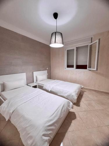 a room with two beds and a pendant light at Corazón de la Ciudad in Tetouan