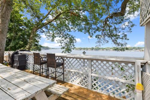 a table and chairs on a deck with a view of the water at Dave's Last Resort - Poolside Cabin 4 Hotel Room in Monticello