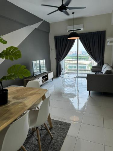 a living room with a table and chairs and a couch at Damai Vacation Stay 7 pax 3 Free Parking in Shah Alam