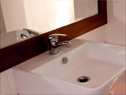 a white sink in a bathroom with a mirror at Vanaro Resort in Yala