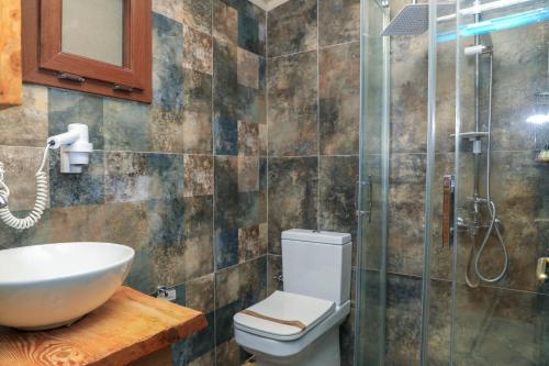 a bathroom with a toilet and a sink and a shower at Symbola Oludeniz Beach Hotel in Oludeniz