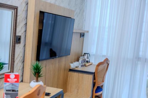 a room with a table and a television on a wall at Bulton Hotel Airport in Arnavutköy