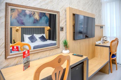 a room with a desk and a tv and a bedroom at Bulton Hotel Airport in Arnavutköy