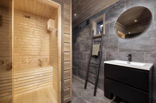 a bathroom with a sink and a mirror at Saga Hytte | 6p | With Sauna, Hot Tub & Water View in Sinnes