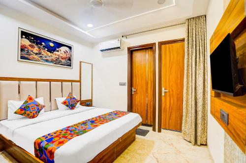 una camera da letto con un letto e una TV a schermo piatto di FabHotel Kishori Inn a Vrindāvan