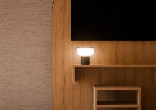 a lamp on a wall with a television on it at Berghotel in Racines
