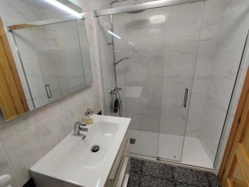 a white bathroom with a shower and a sink at Capitanía frente al mar in Puerto de Mazarrón
