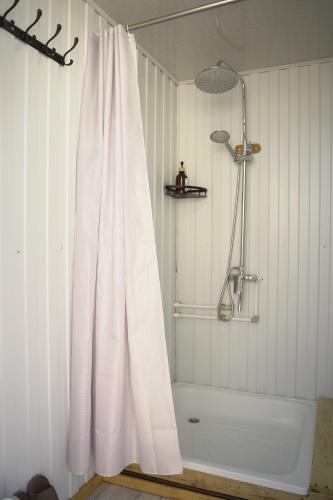 a bathroom with a shower with a white shower curtain at Yurt camp Sonun in Bokonbayevo