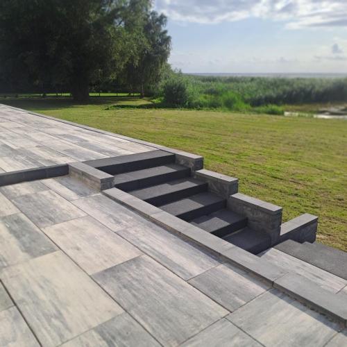 a set of concrete steps on a patio with a grass field at Apartamenty Zagórze 55 in Zagórze