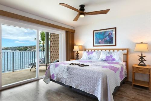 a bedroom with a bed and a balcony at Incredible Ocean Views in Kailua-Kona