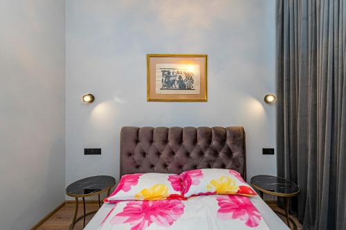 a bedroom with a bed with pink and yellow flowers at The Comfort Apartment #1 by Polo Apartments in Kaunas