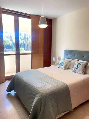 a bedroom with a large bed and a large window at Varandas do Pinhal in Fão