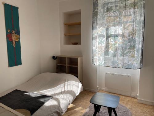 サン・ジュニアンにあるStudio meublé centre-ville Saint Junienのベッドとテーブルと窓のある寝室