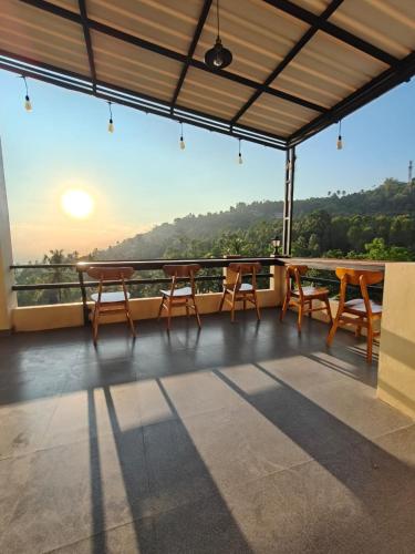 a balcony with tables and chairs and a view at Laras Homestay Munduk in Munduk