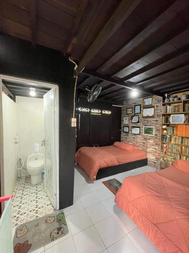 a bedroom with two beds and a toilet in it at Lego Lego Bulubarakka homestay and cafe in Kasijala