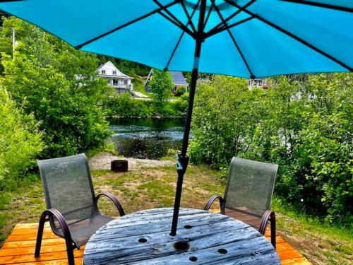 a table with a blue umbrella and two chairs at Lancestral in Saint Come