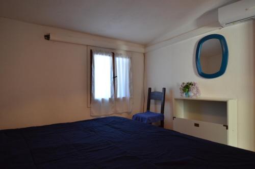 a bedroom with a bed and a window and a chair at Fpo-Rose02p1 in Porto Ottiolu