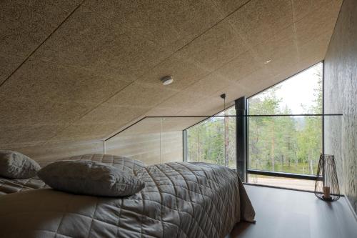 Un dormitorio con una cama grande y una ventana grande. en Villa Arctic Trail, Apartment A, en Äkäslompolo